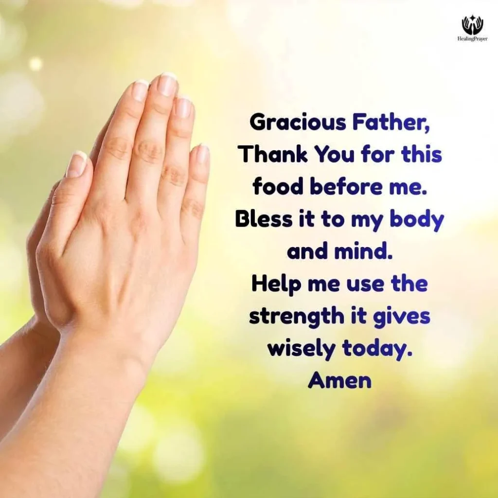 A person quietly praying before eating their lunch, hands clasped over a simple meal.