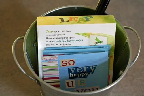 A collection of colorful pens, small papers, and pre-made lunch notes, illustrating supplies for spontaneous note-writing.