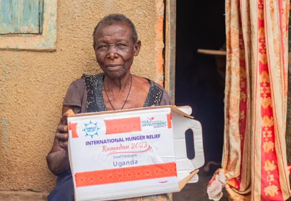 People giving food to those in need, symbolizing Eid charity and hunger relief.