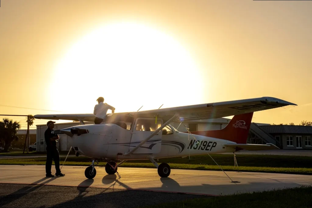 Sunrise over clouds with an airplane wing, representing inspirational aviation and new beginnings.