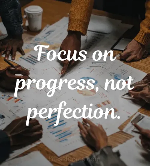 Close-up of a notebook with 'Focus on progress, not perfection.' written, symbolizing productivity.