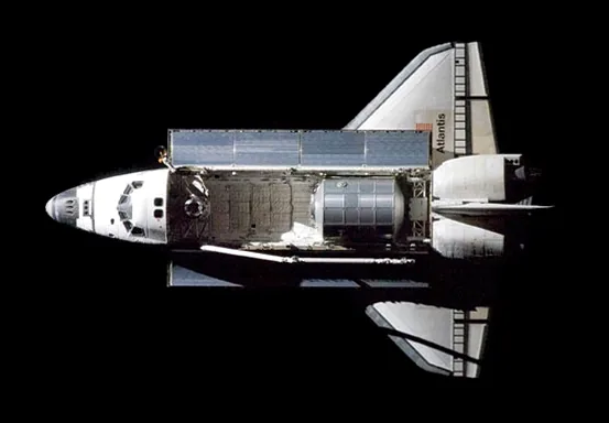 Space Shuttle Atlantis docked with the International Space Station, a symbol of human ingenuity in space.