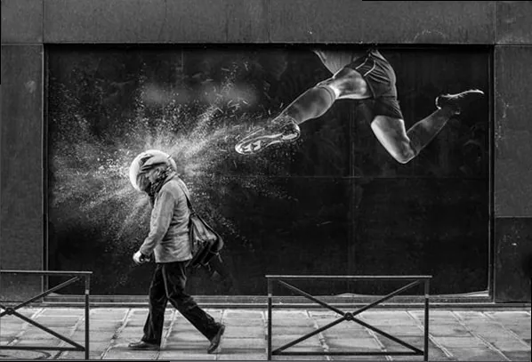 A photographer capturing a candid moment in an urban environment with a small, discreet mirrorless camera, blending into the crowd.