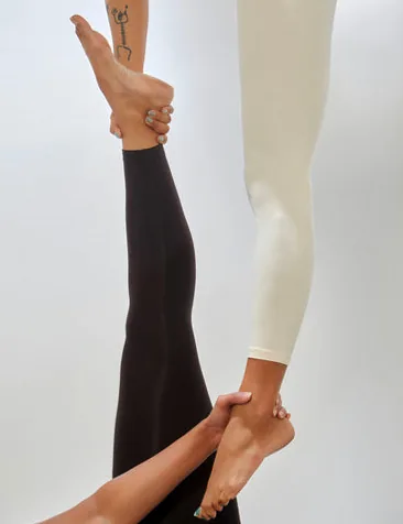 Woman performing a graceful aerial yoga pose with silks
