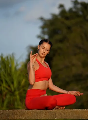 A yogi performing a pose on a beach at sunset, highlighting tranquility and natural connection.