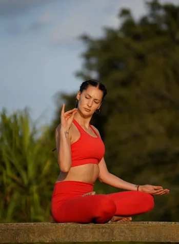 Woman practicing yoga on a serene beach at sunset, with waves gently lapping the shore, embodying peace and connection to nature.