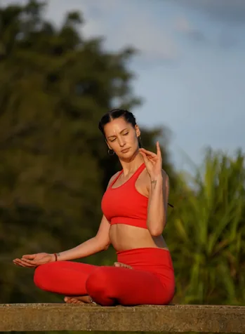 A person practicing yoga on a serene beach at sunset, connecting with nature.