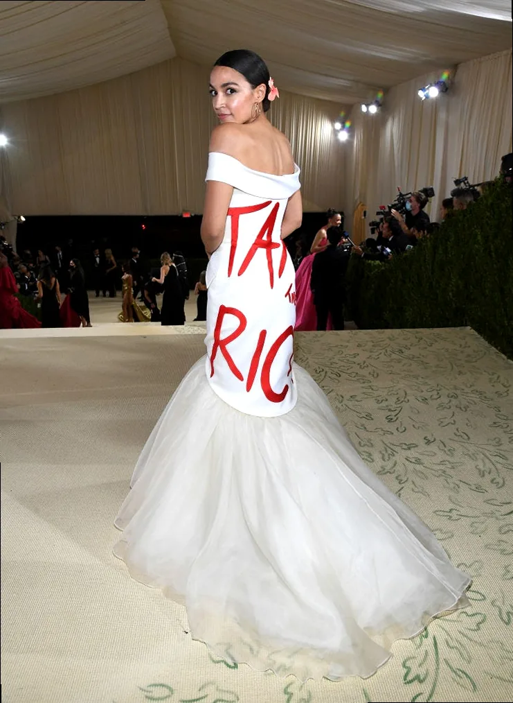 A woman confidently walking a red carpet, embodying empowerment and style.