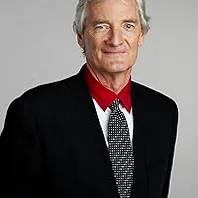 James Dyson, an inventor, observing machinery with a focused expression, embodying practical innovation and engineering prowess.