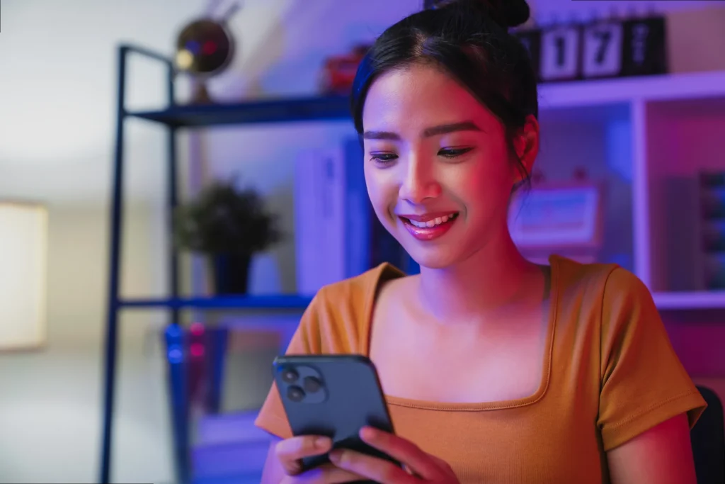 Woman actively managing and optimizing her professional LinkedIn profile on her cell phone for career growth and networking.