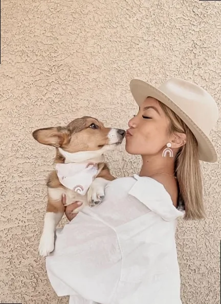 A happy dog mom cuddling her corgi, celebrating Mother's Day.