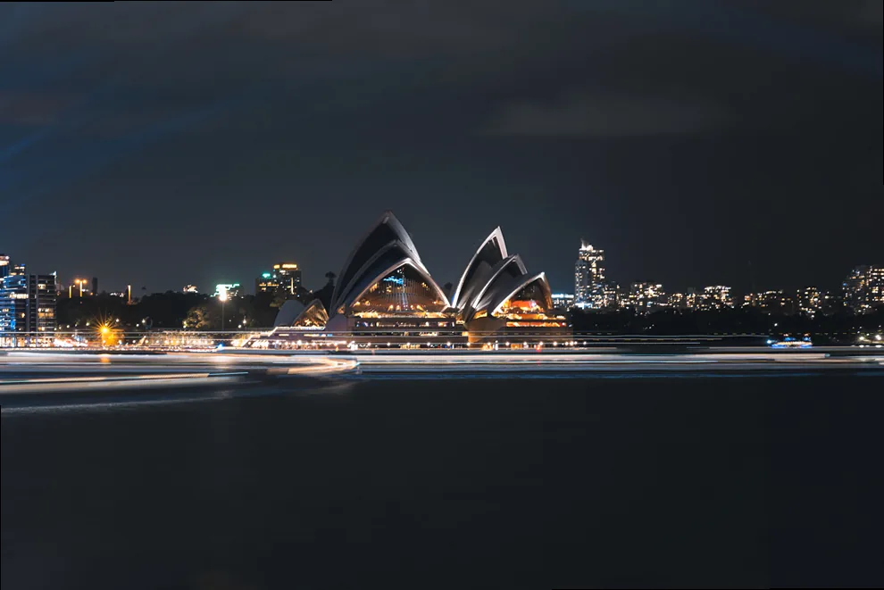 A vibrant light installation reflected in a wet surface on the ground at Vivid Sydney.