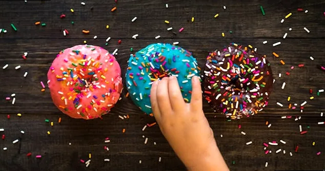 A colorful assortment of classic glazed and sprinkled doughnuts, evoking joy and humor.