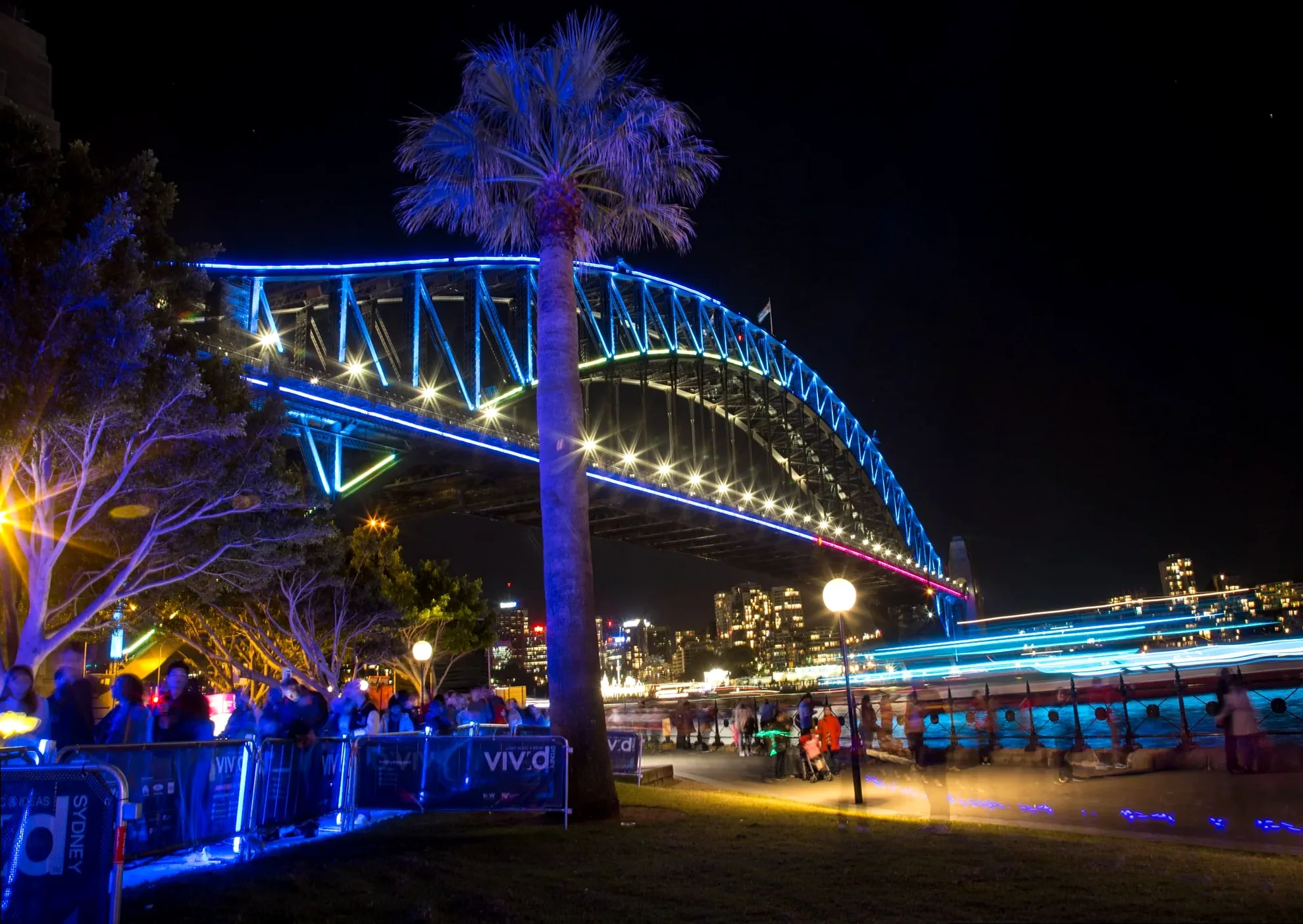 The Sydney Harbour Bridge illuminated with colorful lights, viewed from The Rocks during Vivid Sydney.
