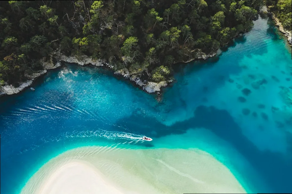 aerial drone view of oludeniz blue lagoon with turquoise sea, paradise white sand beach and tourist boat
