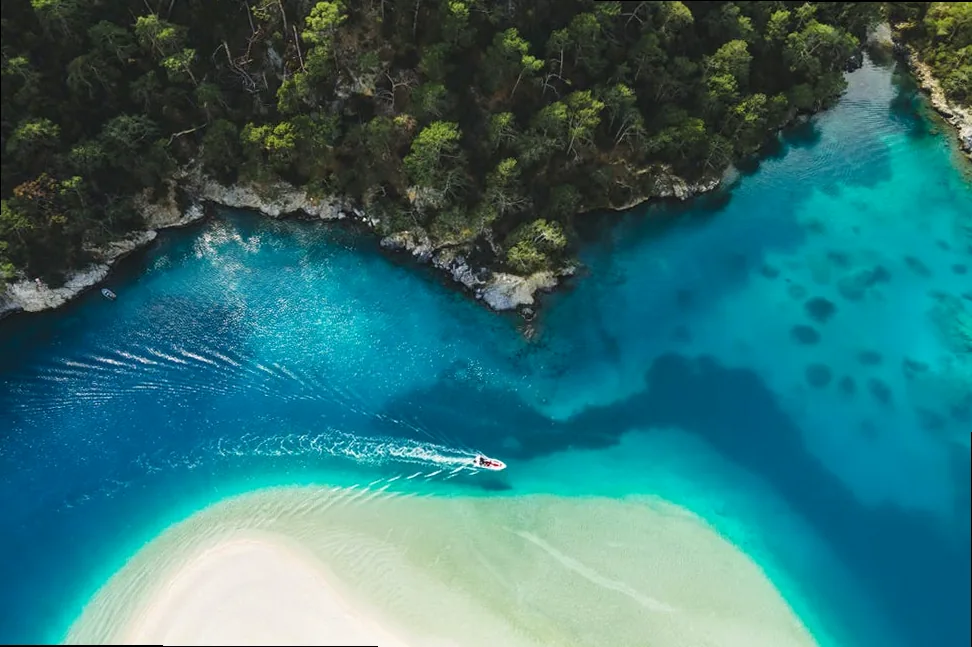 aerial drone view of oludeniz blue lagoon with turquoise sea, paradise white sand beach and tourist boat